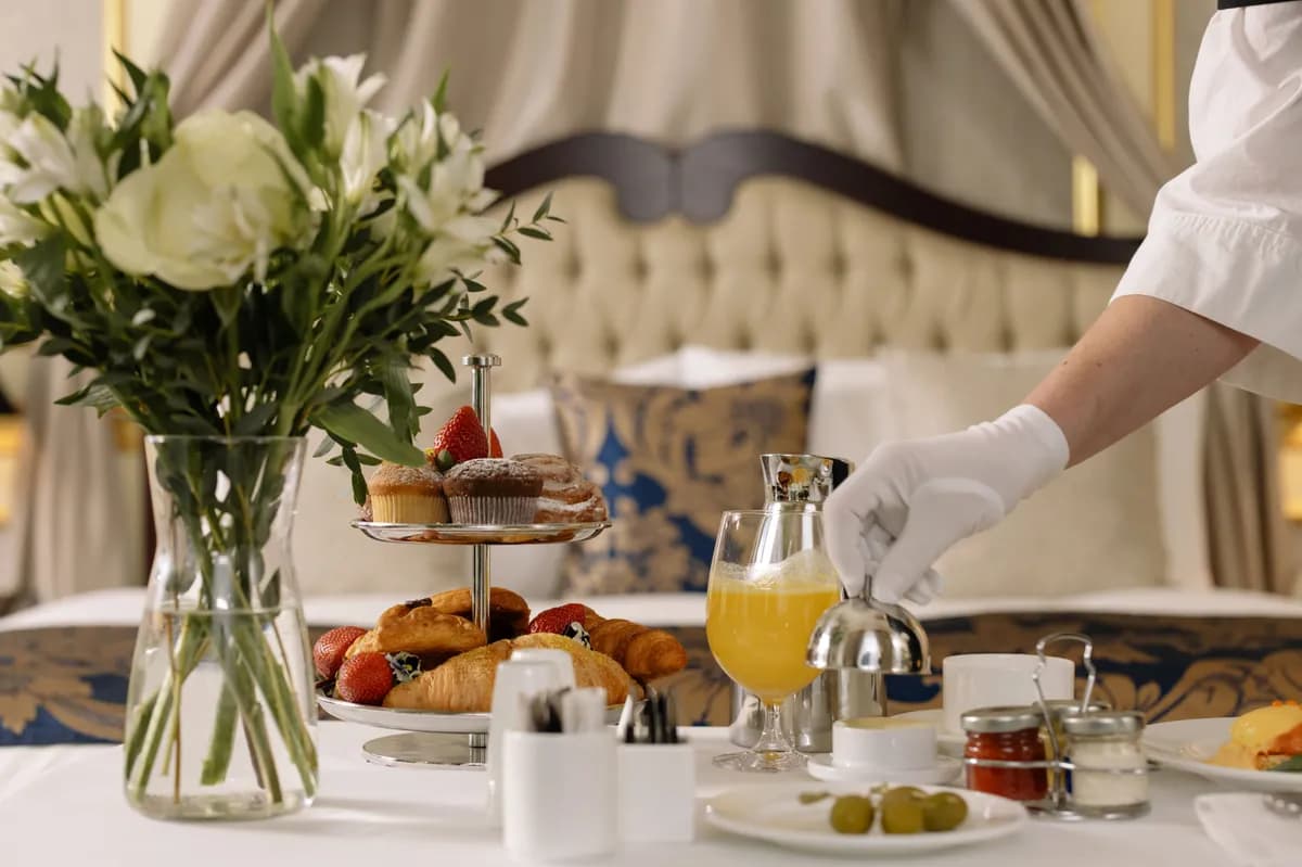 Imagen de ejemplo de BookNoFees: mesa de desayuno con bollería, flores y zumo de naranja servido