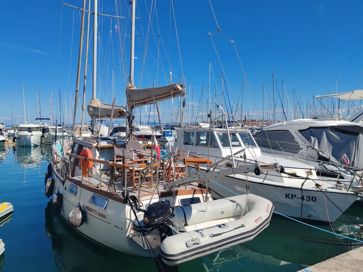 Imagen de ejemplo de BookNoFees: veleros con cubiertas y mástiles de madera amarrados en un embarcadero del puerto