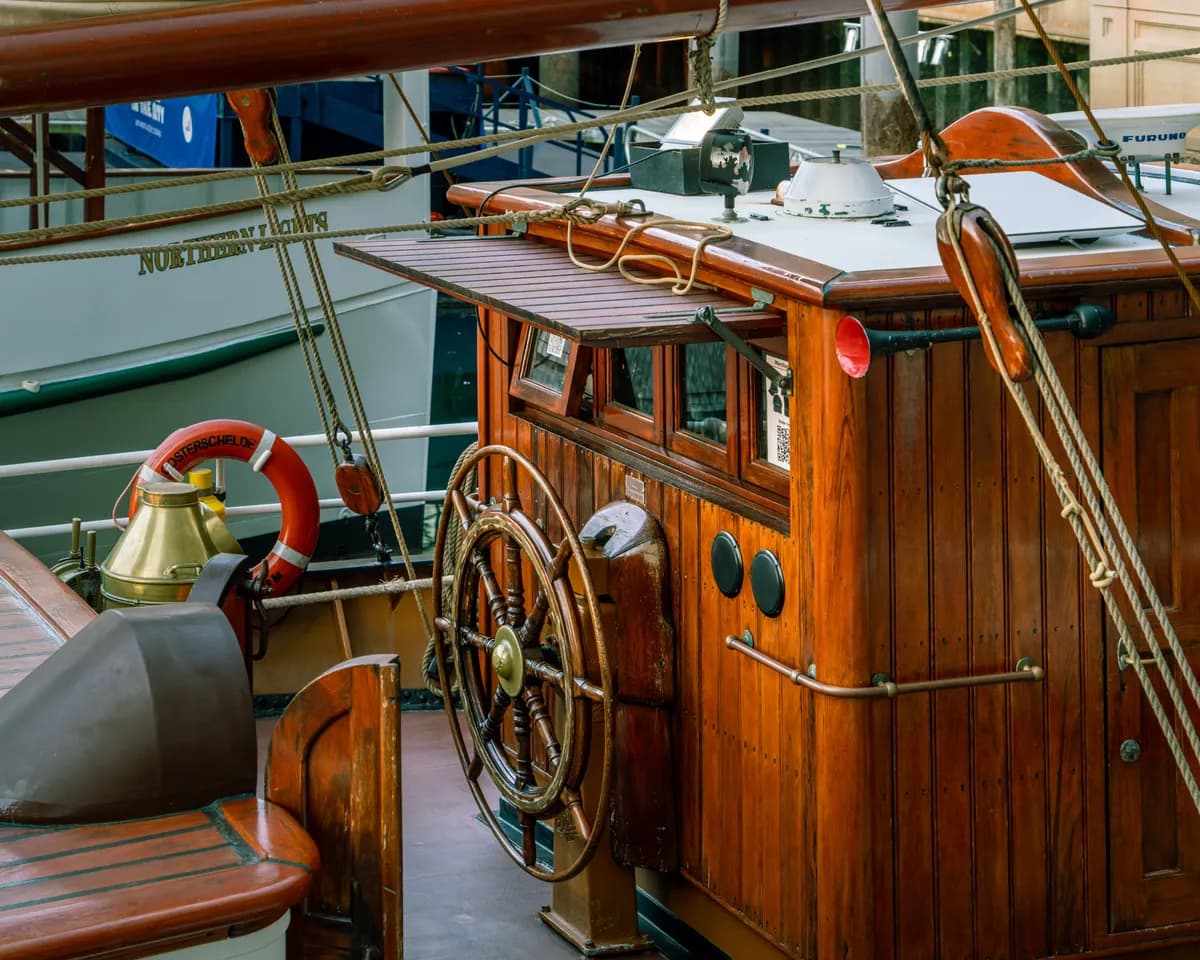 Imagen de ejemplo de BookNoFees: cabina de madera de un barco con timón y aro salvavidas
