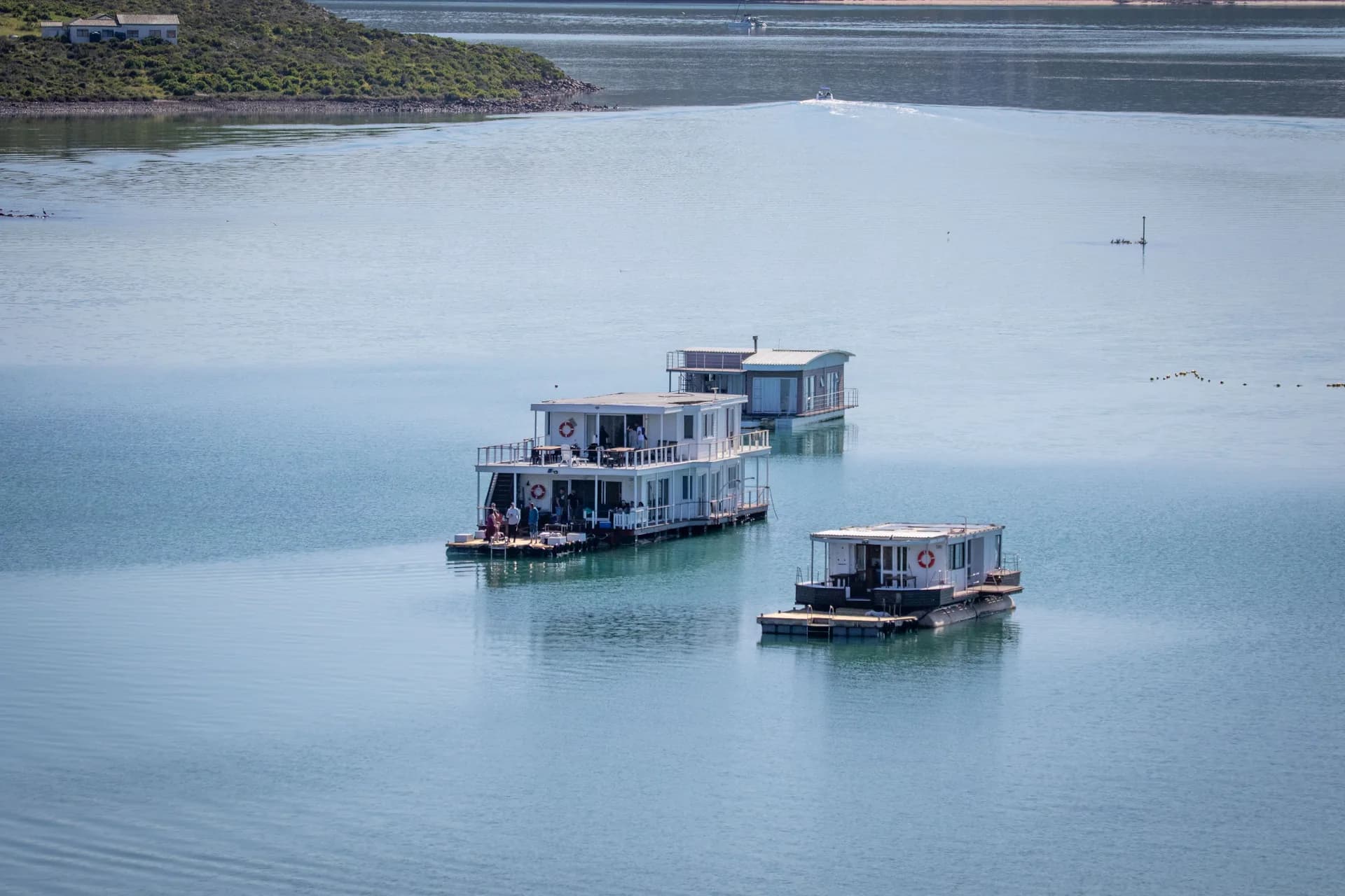 Imagen de ejemplo de BookNoFees: tres casas flotantes en las tranquilas aguas de una laguna
