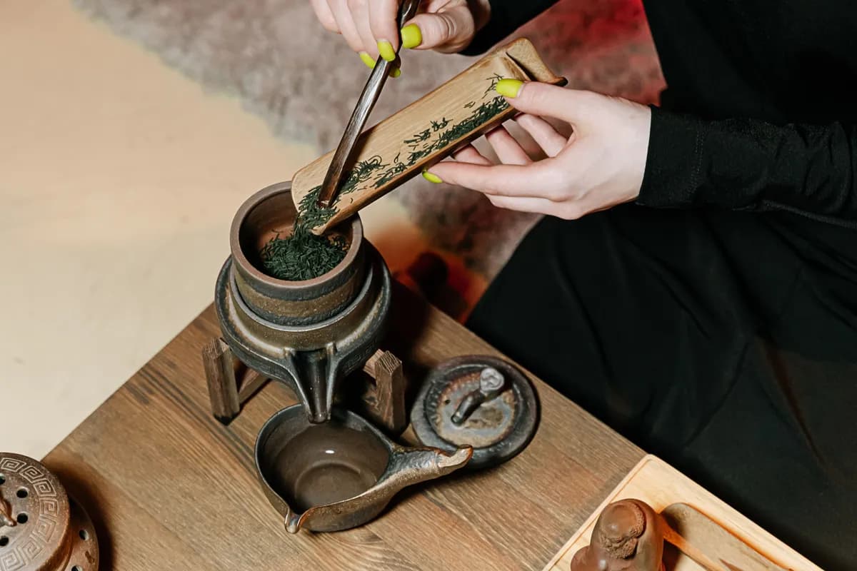 Imagen de ejemplo de BookNoFees: Manos preparando té con una cucharita de bambú