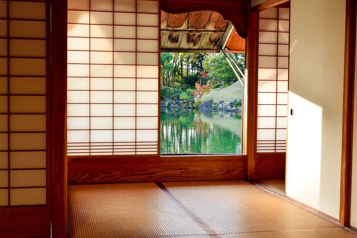 Imagen de ejemplo de BookNoFees: habitación japonesa con puertas correderas y vistas a un estanque en el jardín