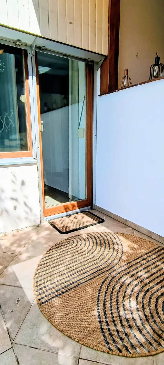 BookNoFees: alquiler vacacional en Straubing, Baviera, Alemania – Zona de entrada con alfombra redonda de tejido y puerta corredera de cristal