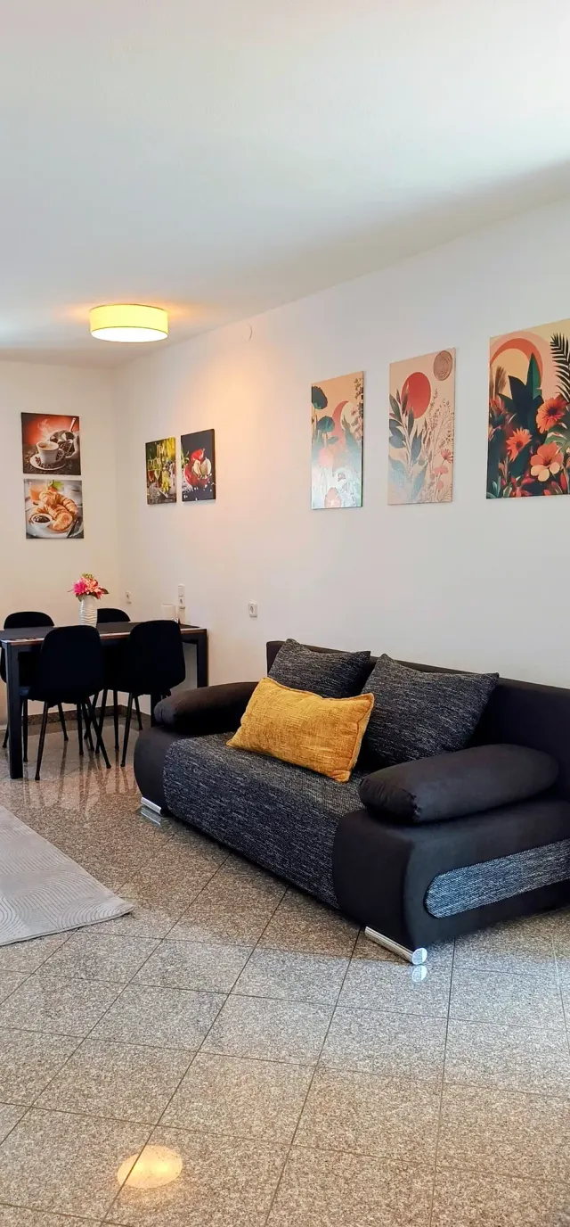 BookNoFees: alquiler vacacional en Straubing, Baviera, Alemania – Salón con sofá, mesa de comedor y arte de pared