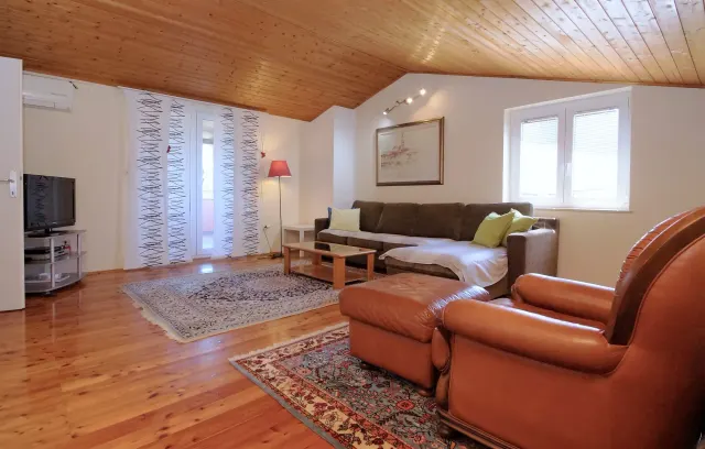 BookNoFees: alquiler vacacional en Fažana Valbandon, Condado de Istria, Croacia – Salón con sofá marrón, sillón de cuero, techo de madera y alfombras estampadas