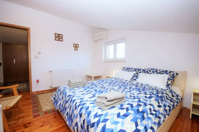 BookNoFees: alquiler vacacional en Fažana Valbandon, Condado de Istria, Croacia – Dormitorio con cama de matrimonio, ropa de cama con motivos azules y suelo de madera