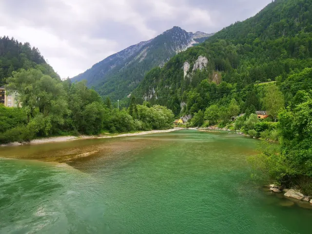 BookNoFees: alquiler vacacional en Hieflau, Estiria, Austria – Vista del río con montañas boscosas y una casa amarilla a orillas del río