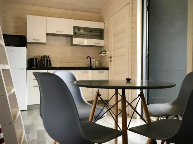 BookNoFees: alquiler vacacional en Jarosławiec, Polonia – Una pequeña cocina con mesa y sillas en el complejo DOMKI SILVER 2, en la ciudad de Jarosławiec