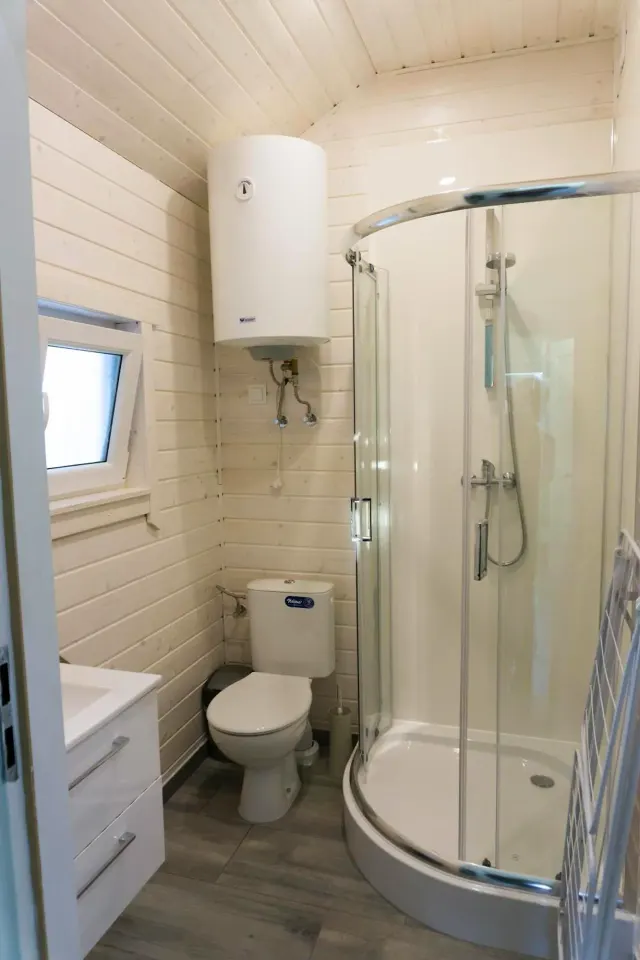 BookNoFees: alquiler vacacional en Jarosławiec, Polonia – Un pequeño cuarto de baño con aseo y ducha en el complejo DOMKI SILVER 2, en la ciudad de Jarosławiec