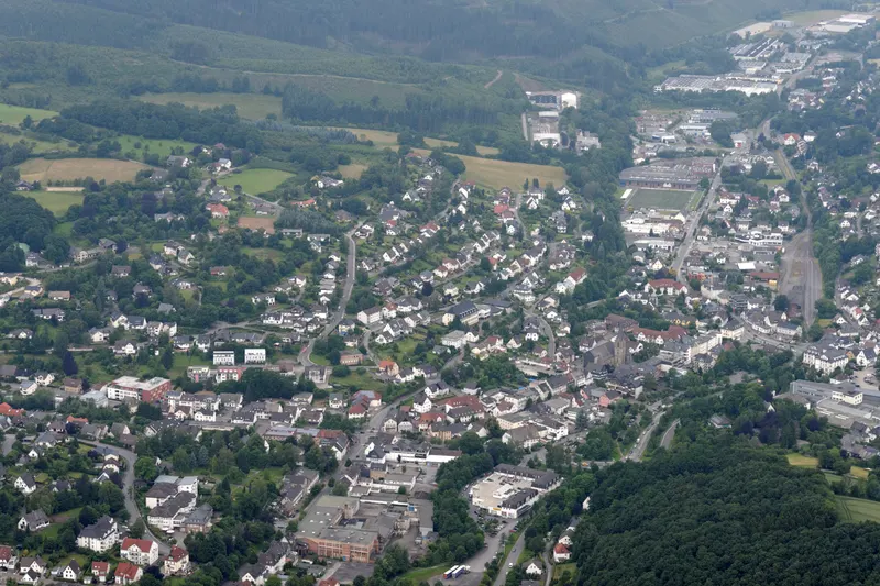 La localidad de Sundern vista desde el aire, con sus casas a lo largo del valle del Röhr, entre colinas boscosas