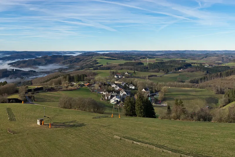 Wildewiese, en las colinas del Sauerland, con un remonte en la pradera y el pueblo a sus pies