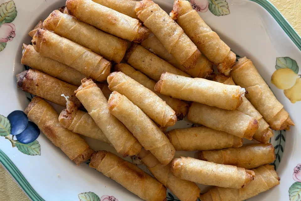 Foto de ejemplo: Rollitos de primavera fritos y dorados en un plato estampado