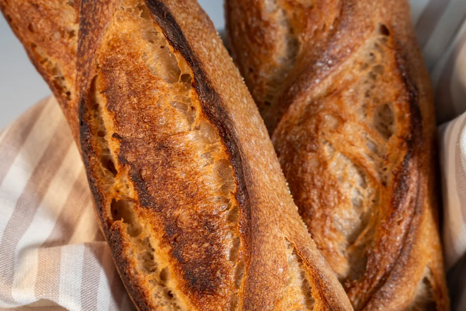 BookNoFees: Foto de ejemplo: Baguettes de color dorado-marrón sobre un mantel a cuadros