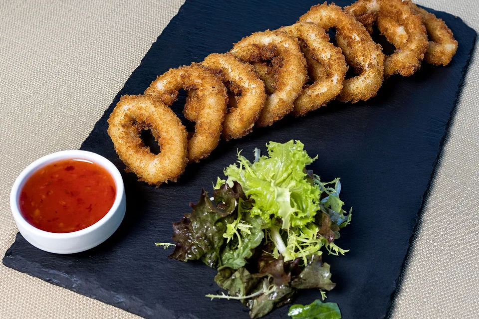 Foto de ejemplo: Anillas de calamares fritos con ensalada y salsa para mojar
